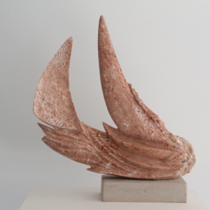 Sculpture abstraite en pierre rose veinée de terre cuite, en forme de voiles ou d'ailes courbées, posée sur une base en pierre beige.
