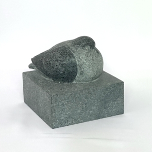 Sculpture lisse en pierre à savon grise représentant un pigeon endormi et recroquevillé, posée sur une base cubique en pierre grise assortie.
