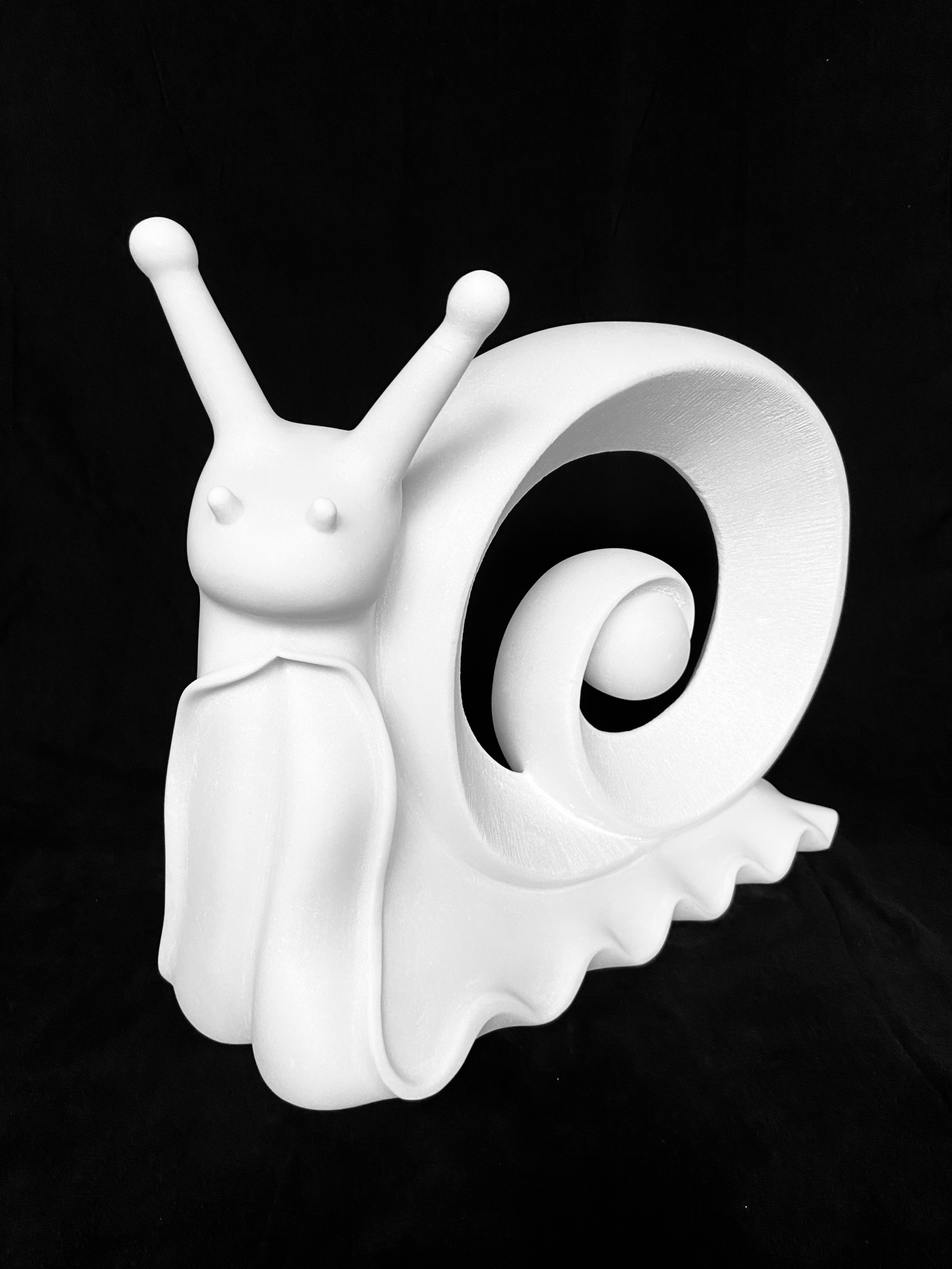 White marble sculpture of a snail with an extended head and a spiraling shell.